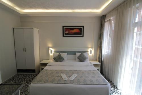 a hotel room with a bed with slippers on it at Lemon Residence in Istanbul
