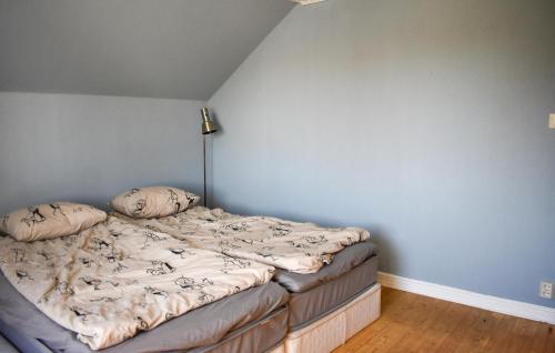 an unmade bed in a bedroom with a blue wall at 4 Bedroom Stunning Home In Löderup in Löderup