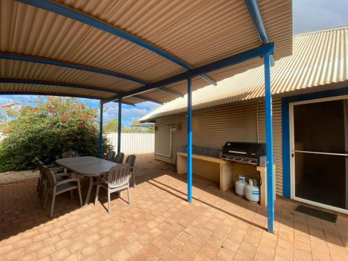 a patio with a table and chairs and a grill at Osprey Holiday Village Unit 111 in Exmouth