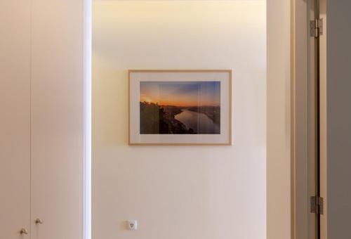 a picture hanging on a white wall in a room at GuestReady - Catorze de Outubro Houses 427 in Vila Nova de Gaia