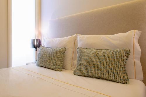 a white bed with two pillows and a headboard at GuestReady - Catorze de Outubro Houses 427 in Vila Nova de Gaia