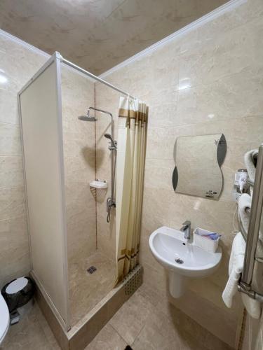 a bathroom with a shower and a sink at Hotel Chicago in Umanʼ