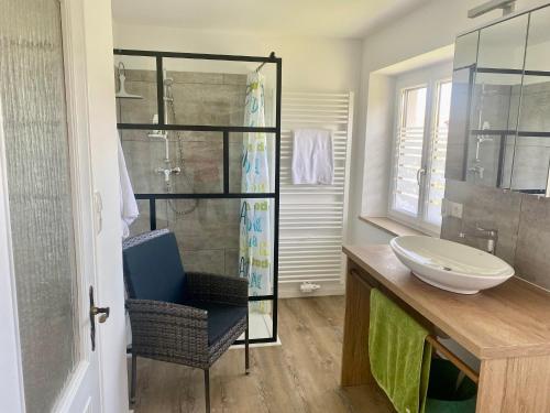 a bathroom with a sink and a glass shower at Ferienwohnung Altes Zollhaus in Ering