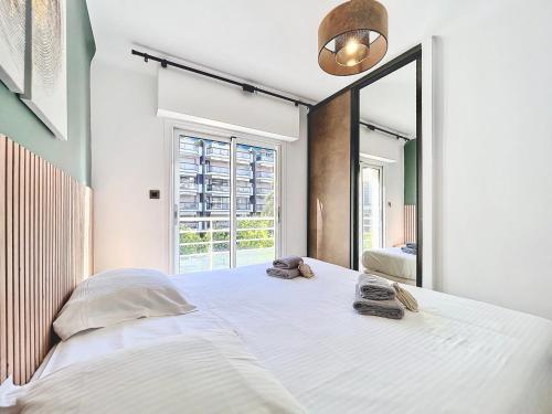 - une chambre avec un grand lit blanc et un grand miroir dans l'établissement 2 BR Croisette balcony & sea view Olam Properties, à Cannes