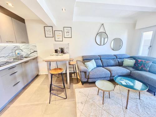 un salon avec un canapé bleu et une cuisine dans l'établissement 2 BR Croisette balcony & sea view Olam Properties, à Cannes