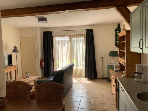 a kitchen with a couch and a table and a window at Christinahoeve Logies Oude Deel in Boskoop