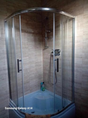 a shower with a blue tub in a bathroom at Kötél utcai vendégház in Balatonkeresztúr