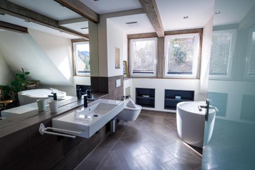 a bathroom with two sinks and a toilet at Bergwirt Hotel & Gasthof in Kiefersfelden