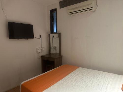 a bedroom with a bed and a flat screen tv at Jenny Homestay in Teluk Intan