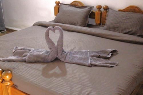 two swans made out of towels on a bed at Casa Hillary Guest House in Colva