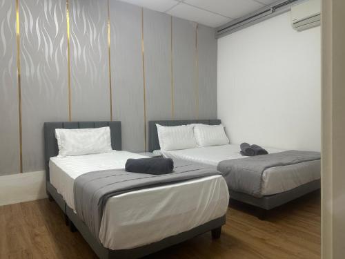 two beds in a room with two beds sidx sidx sidx at Jenny Homestay in Teluk Intan
