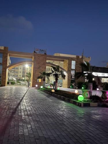 ein großes Gebäude mit einer Backsteinstraße davor in der Unterkunft Tahiti resort north coast in Dawwār ‘Abd Allāh