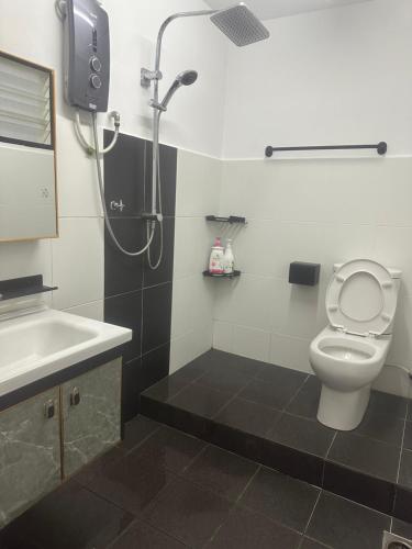 a bathroom with a shower and a toilet and a sink at Jenny Homestay in Teluk Intan