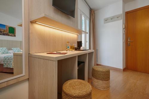 a room with a counter and a room with a bed at Hotel Colonial in Colonia Sant Jordi
