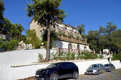two cars parked in front of a building at Doliva Studio Anthi private jacuzzi in Agios Gordios