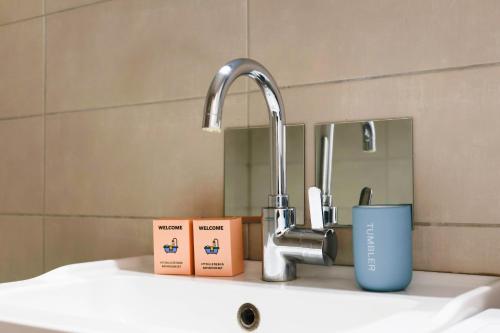 - un lavabo avec un robinet et une tasse dans l'établissement M18 Marquer T3 proche gare d'Annemasse, à Annemasse