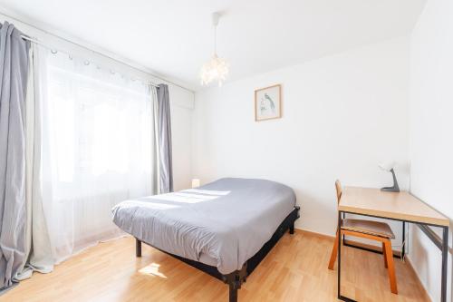 une chambre avec un lit, un bureau et une fenêtre dans l'établissement M18 Marquer T3 proche gare d'Annemasse, à Annemasse