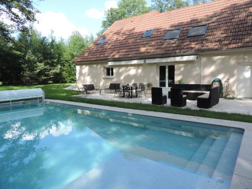 une grande piscine devant une maison dans l'établissement Maison neuve avec piscine dans domaine arboré - Domaine de la Brionnerie, à Sommecaise
