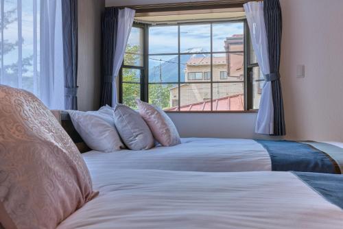 a bedroom with two beds and a large window at RISA INN Fuji in Fujiyoshida