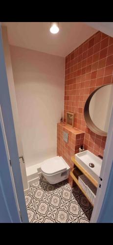 une salle de bain avec toilettes, lavabo et miroir dans l'établissement Charmant appartement 65m2 mairie de saint ouen - carrefour pleyel, à Saint-Denis