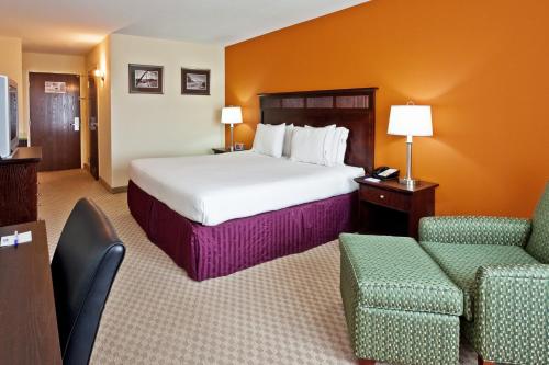 a hotel room with a bed and two chairs at Holiday Inn Express & Suites Chattanooga-Hixson by IHG in Hixson