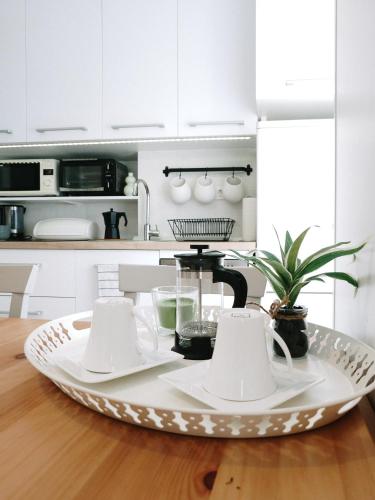 a kitchen with white cabinets and a tray with dishes at Apartment Astina in Koper