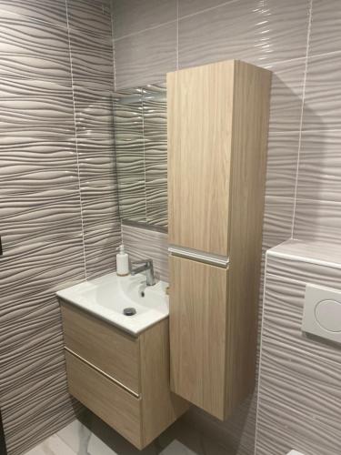 La salle de bains est pourvue d'un lavabo et d'une armoire en bois. dans l'établissement Maison avec 6 Chambres et 4SDB à 15min de Disney, à Jossigny