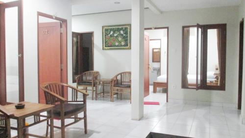 a living room with chairs and a table and a mirror at Vinandaka Homestay in Sanur