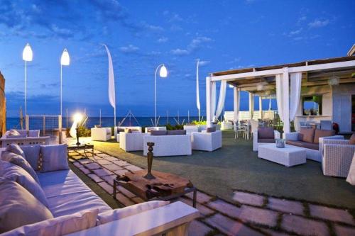 a patio with white furniture and the ocean at night at Villa Paola by the sea in Cozze