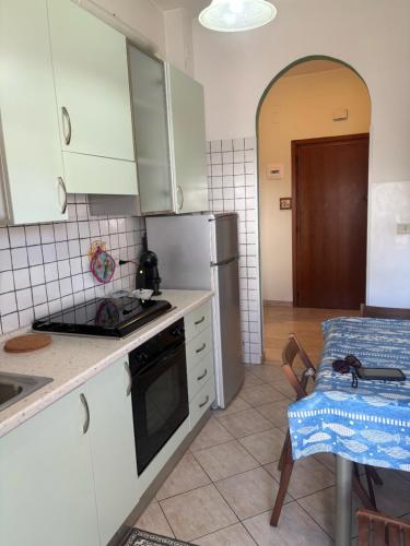 una cucina con mobili bianchi e un forno a piano cottura di Casa Talassa a Pescara