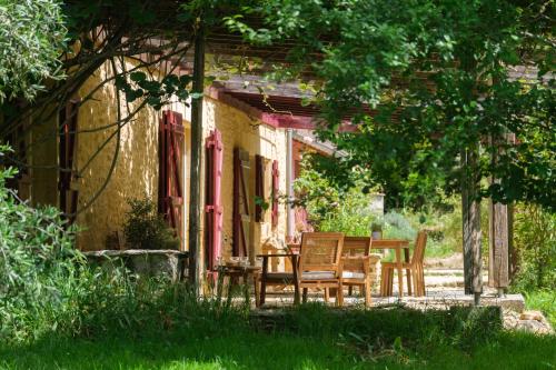 une table et des chaises assises à l'extérieur d'une maison dans l'établissement La Maison de Jennie, à Saint-André-dʼAllas