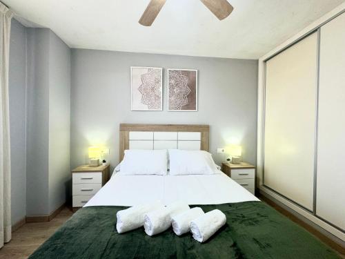 a bedroom with a large white bed with two towels at Beach Apartment, Torre Benagalbón in Torre de Benagalbón