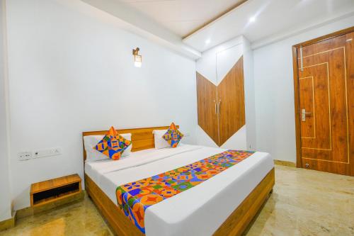 a bedroom with a bed and a wooden door at FabHotel Amrit Residency Near Udyog Vihar, Gurgaon in Gurgaon