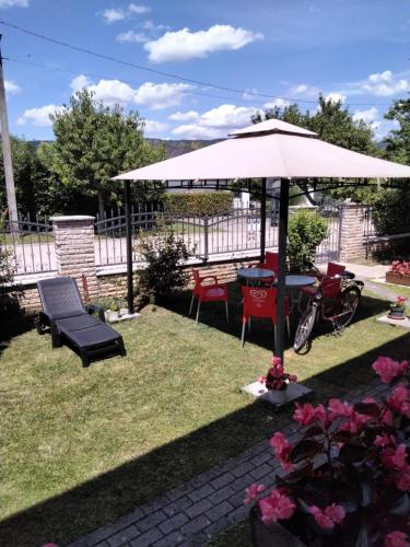 a patio with an umbrella and a table and chairs at Magdaléna Vendégház in Esztergom