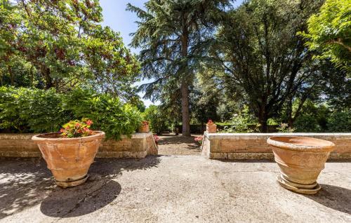 two large pots with flowers in them in a garden at Villa Martelli in Capannoli