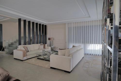 a living room with two white couches and a glass table at Villa Continental 4bedrooms in Tangier