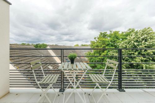 a balcony with a table and chairs on a roof at OVELIA Herblay - L'Orée des Ormes in Herblay