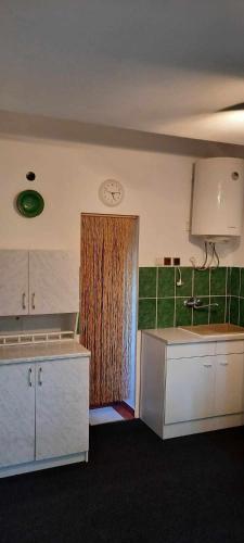 a kitchen with a door with a clock on the wall at G&G Vacation Home in Cîlnic