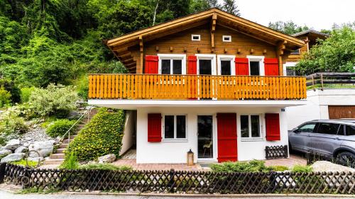 a house with red doors and a balcony at Chalet Tannen Hüsli, Breiten in Breiten