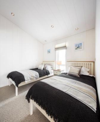 a bedroom with two beds and a window at Ebba Lodge in Eyemouth