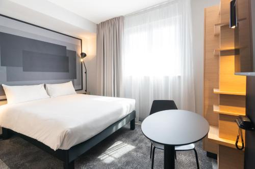 a bedroom with a bed and a desk and a table at ibis Strasbourg Centre Gare in Strasbourg