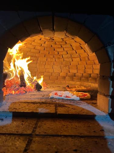 a brick oven with two pizzas in it at Villa Natina in Pizzo