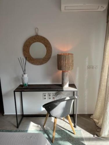 a table with a lamp and a chair in a room at Dreamscape Villa Oneiro - Your Gateway to Seaside in Évyiros