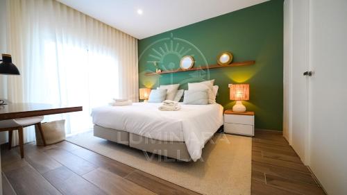 a bedroom with a bed and a green wall at Luminara Villa in Santa Luzia
