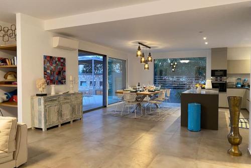 a kitchen and living room with a table and a dining room at Dreamscape Villa Oneiro - Your Gateway to Seaside in Évyiros