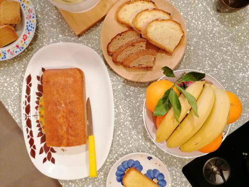 a table topped with plates of food with bread and fruit at ALPINO B&B in Chiesa in Valmalenco