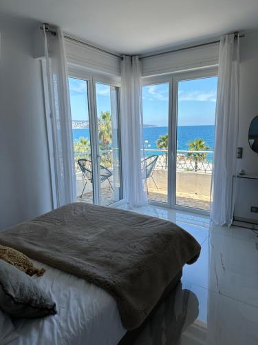 une chambre avec un lit et une vue sur l'océan dans l'établissement Beach front, Superbe appartement pour 4 personnes, à Nice