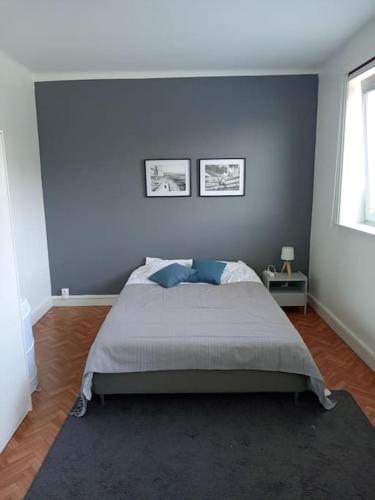 une chambre avec un grand lit aux murs bleus dans l'établissement Appartement pour 6 personnes proche métro eurotéléport, à Roubaix