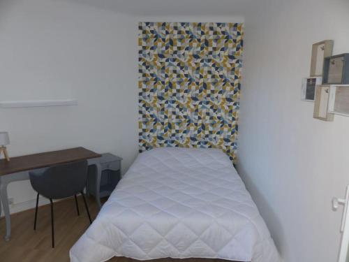une petite chambre avec un lit et un bureau dans l'établissement Appartement pour 6 personnes proche métro eurotéléport, à Roubaix