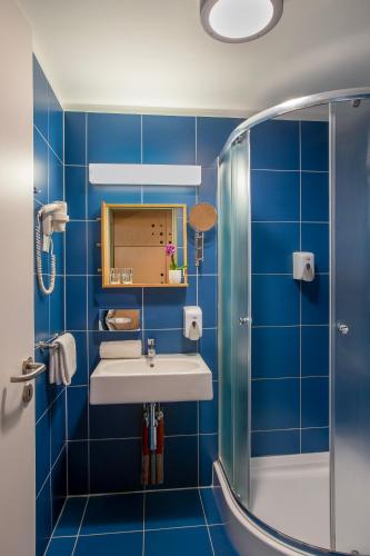 a blue bathroom with a sink and a shower at Alsóörs Marina in Alsóörs